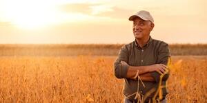 Produtor rural ao lado de maquinário agrícola